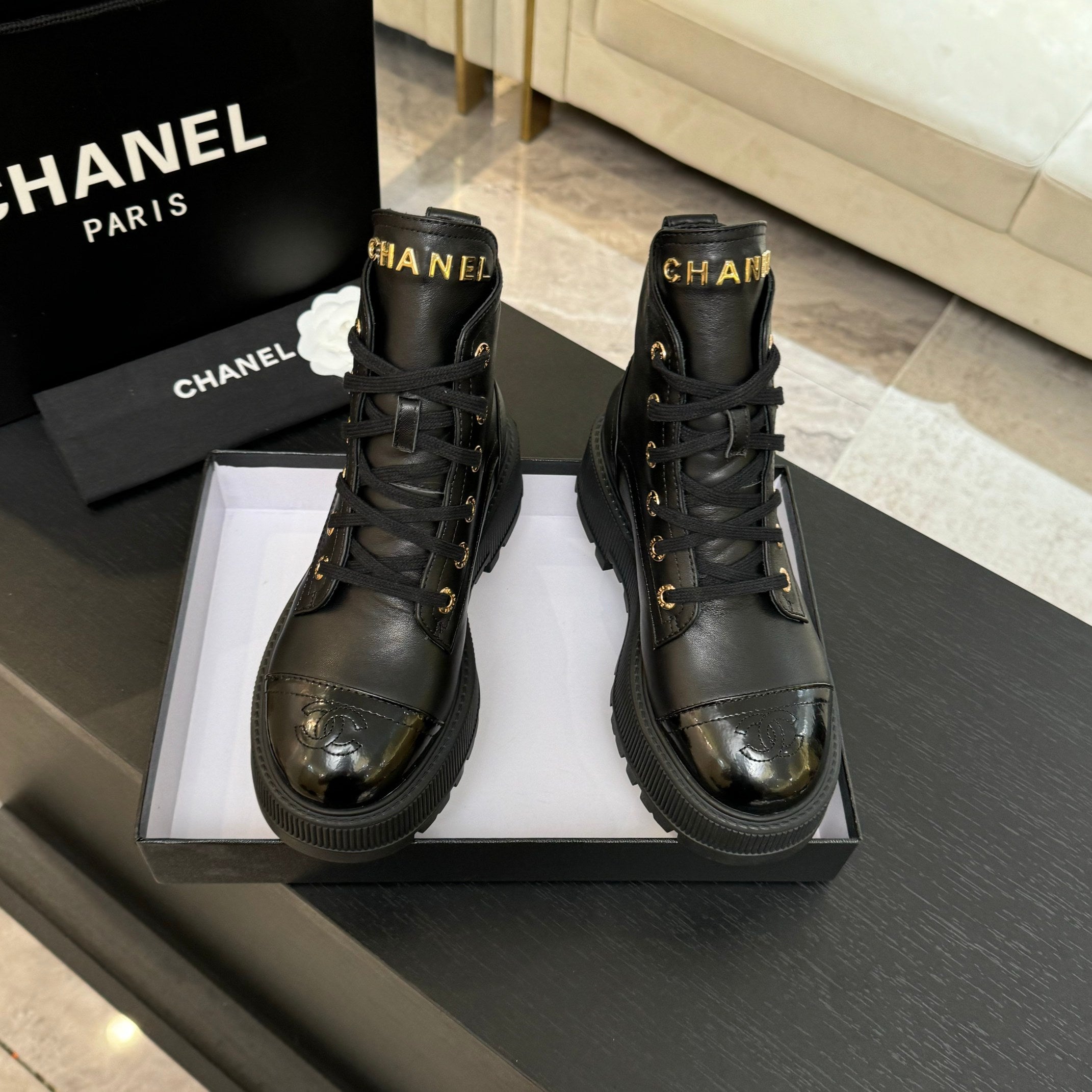 Chanel black leather lace-up ankle boots with shiny toe caps and gold eyelets