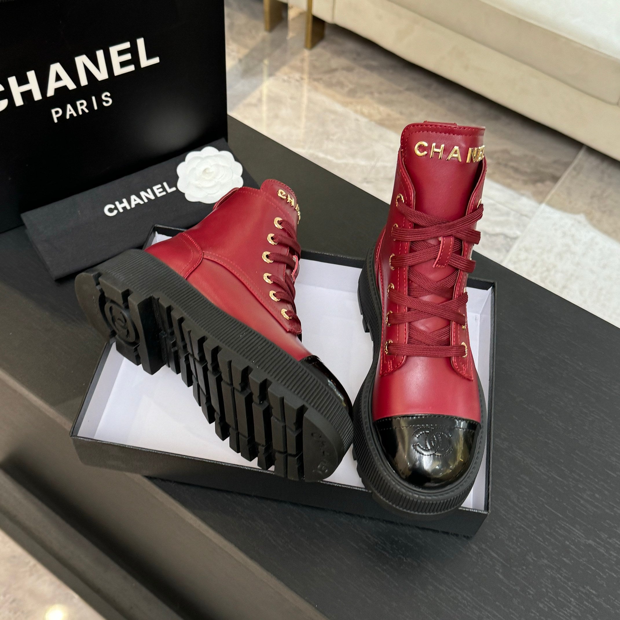 Chanel ladies red lace-up high-top boots showing tread soles and glossy toe caps