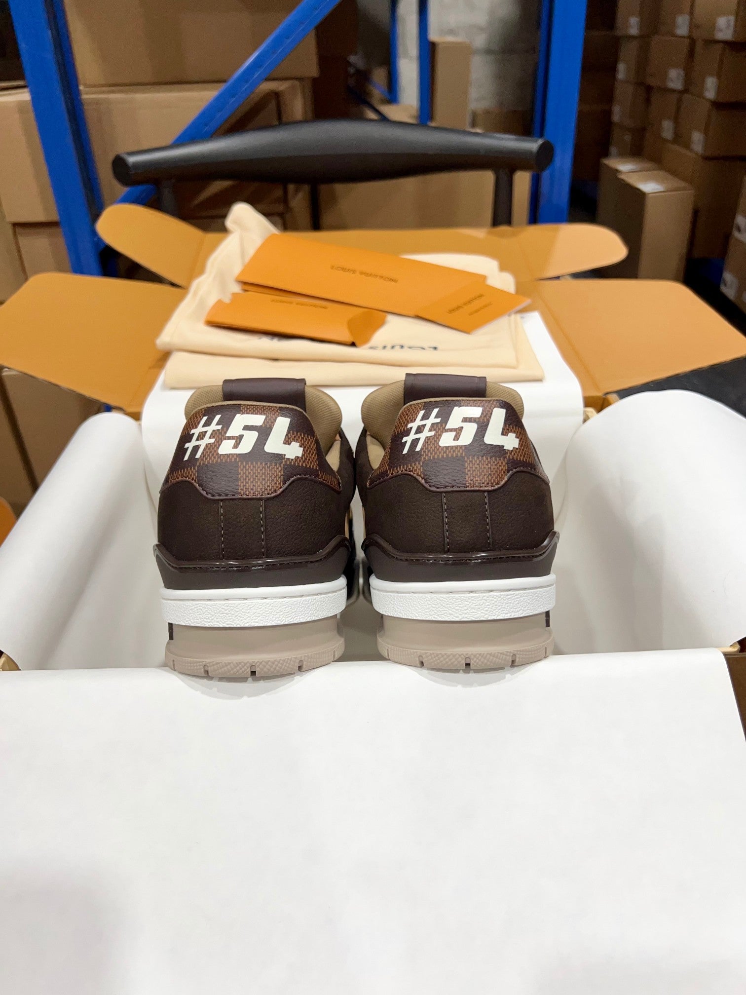Louis Vuitton trainer sneakers viewed from back, dark brown uppers and white outsole