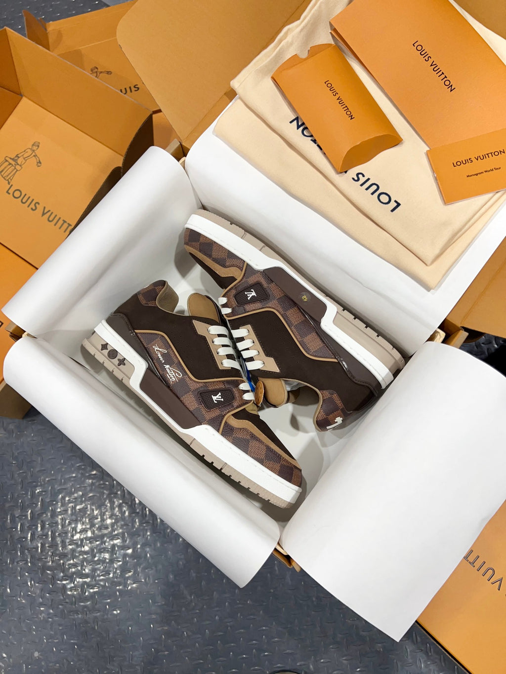 Close view of Louis Vuitton trainer sneakers, dark brown camo pattern and white lace trim