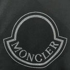 Close-up of rhinestone heart logo with Moncler text on a black sweatshirt