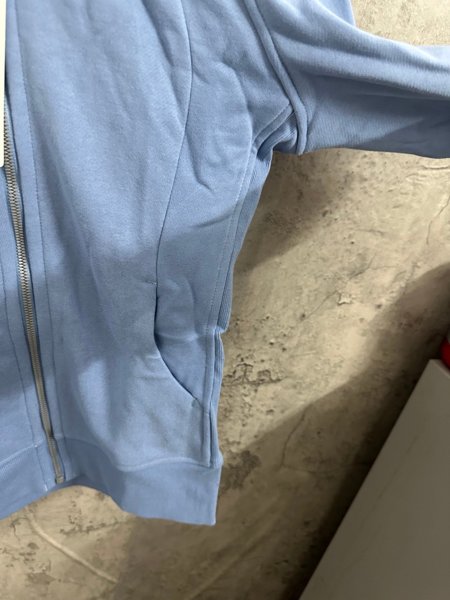 Light blue zip-up hoodie side panel with seam details
