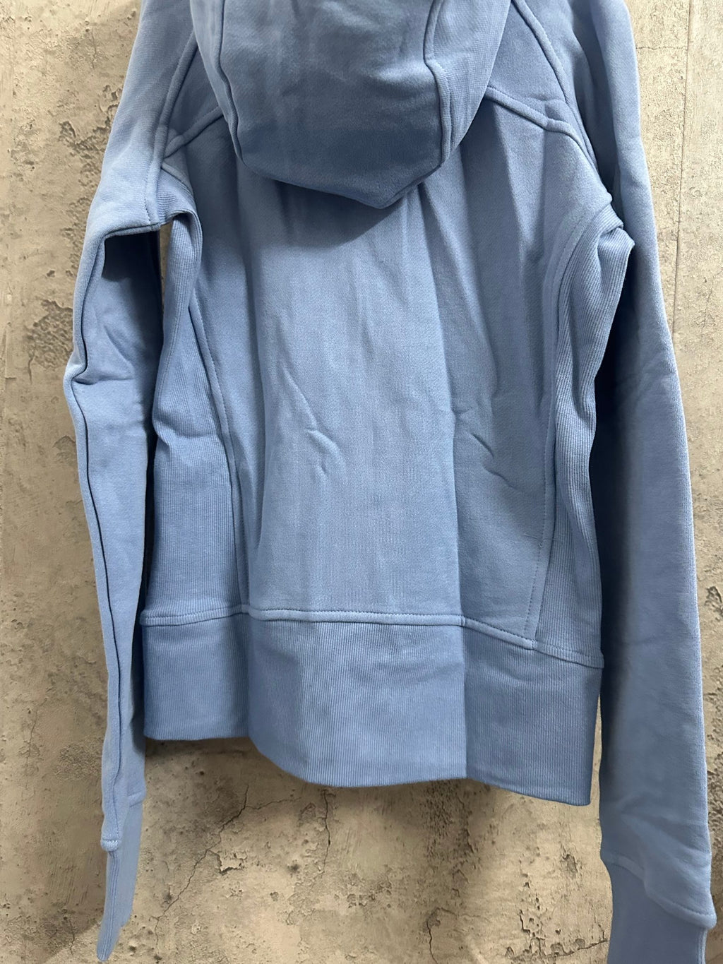 Light blue hooded zip-up sweatshirt with kangaroo pocket and draped back panel