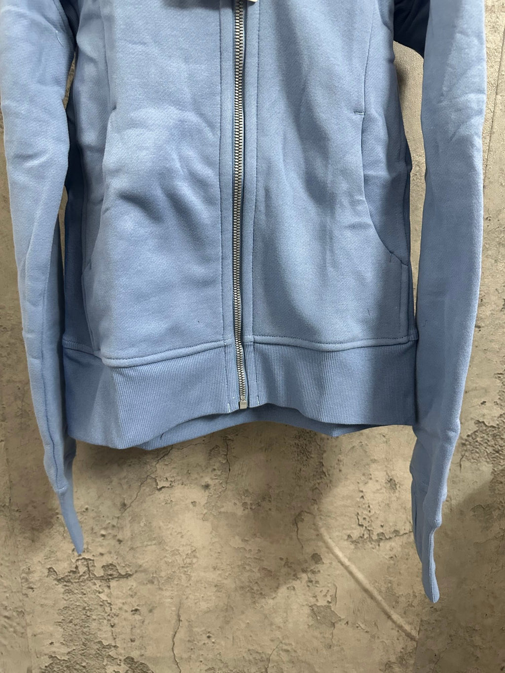 Light blue zip-up hoodie front panel with zipper and hem