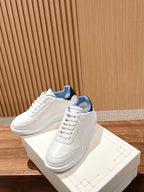 Pair of white lace-up leather sneakers with blue collar lining.