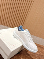White leather sneaker with blue collar lining and embossed logo detail.