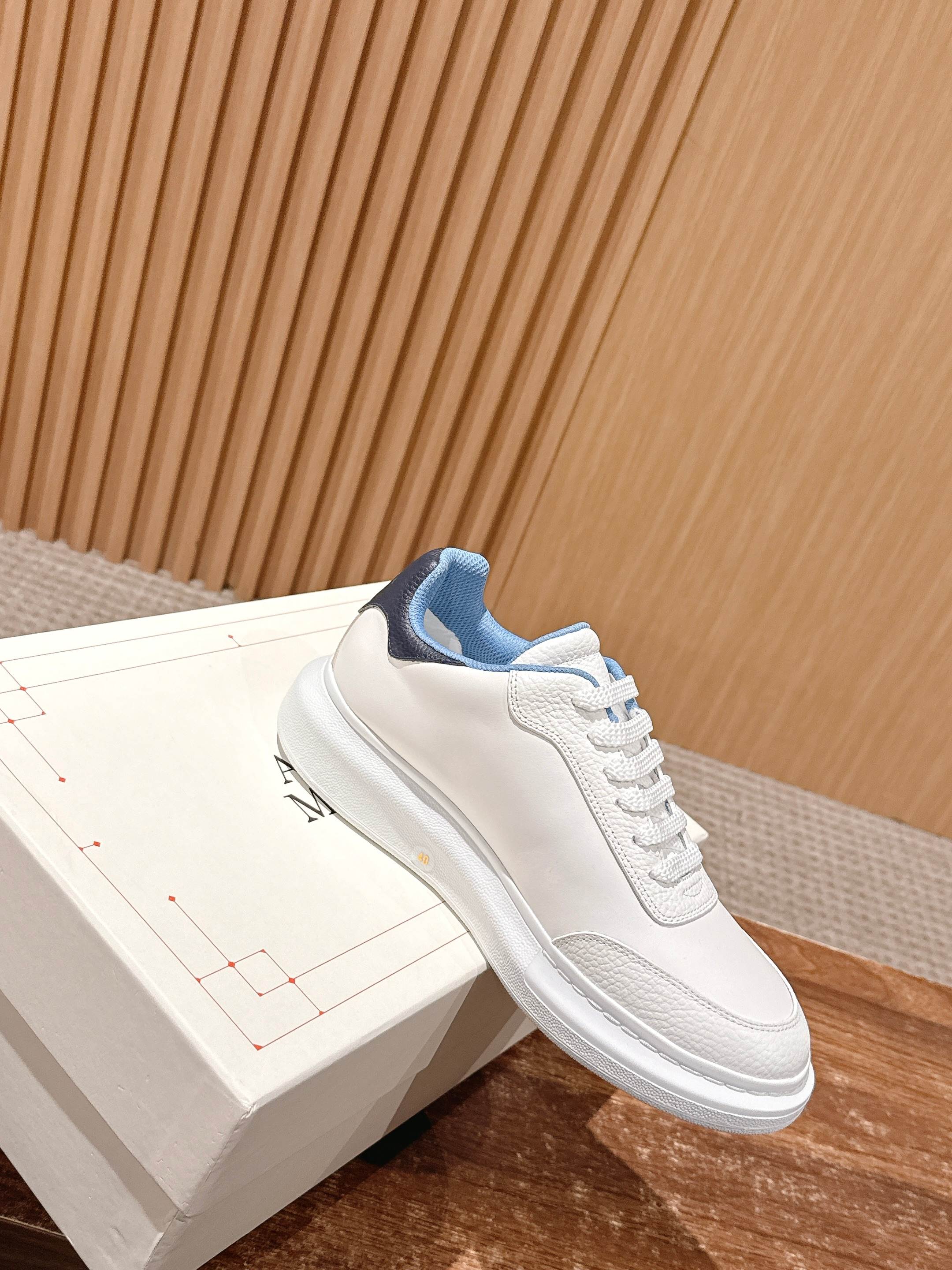 White leather sneaker with blue collar lining and embossed logo detail.