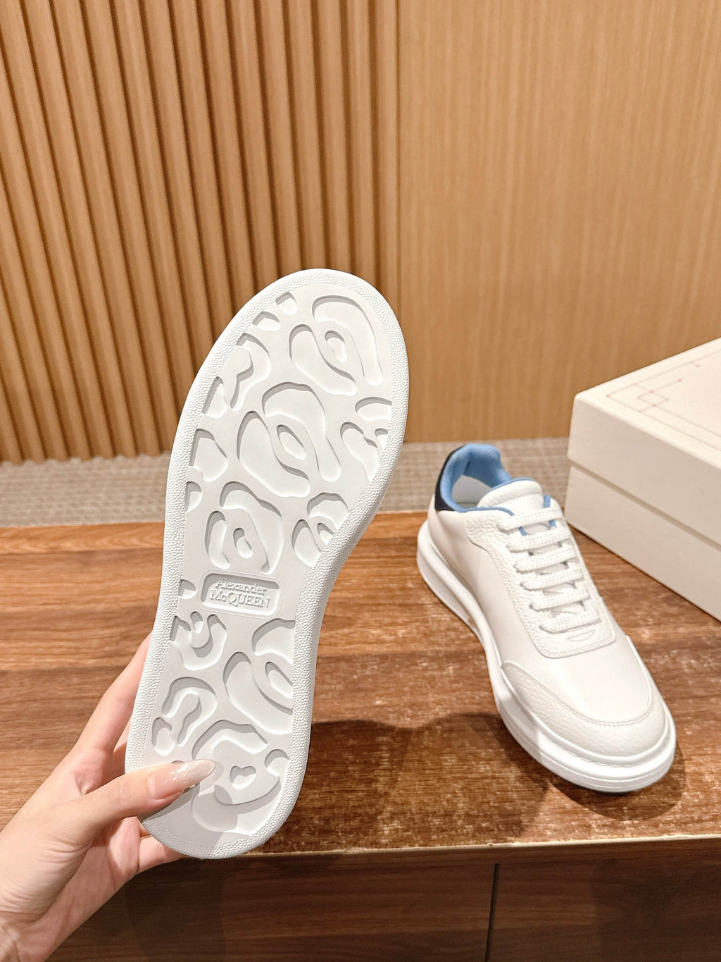 White rubber outsole with patterned tread, next to matching sneaker.