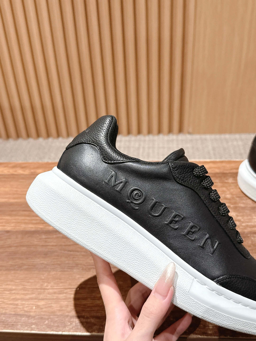 Black leather sneaker with embossed McQUEEN lettering and white sole