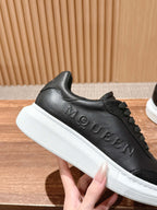 Black leather sneaker with embossed McQUEEN lettering and white sole