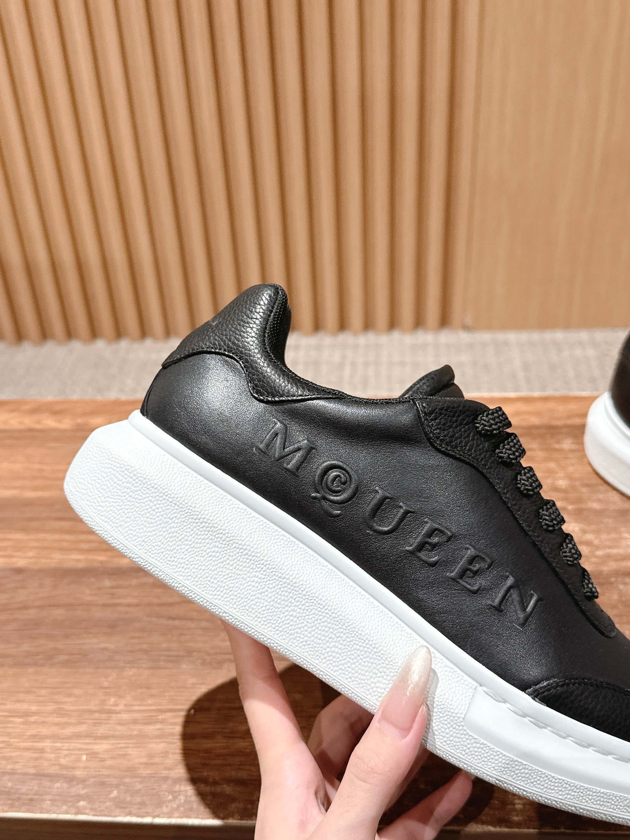 Black leather sneaker with embossed McQUEEN lettering and white sole
