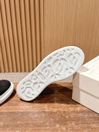 Bottom view of a black sneaker outsole with white tread pattern
