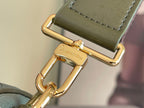 Louis Vuitton gold-tone clasp on green leather strap, metal hardware close-up