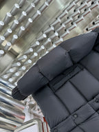 Long puffer jacket sleeve and lower back in dark gray with ribbed cuffs and buttons