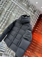 Long puffer jacket in dark gray with hood and quilted design; sleeve pocket logo patch