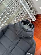 Long puffer jacket in dark gray with hood and quilted panels; button-up front
