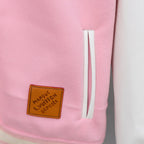 Pink jacket side with brown Louis Vuitton patch and white stripe trim