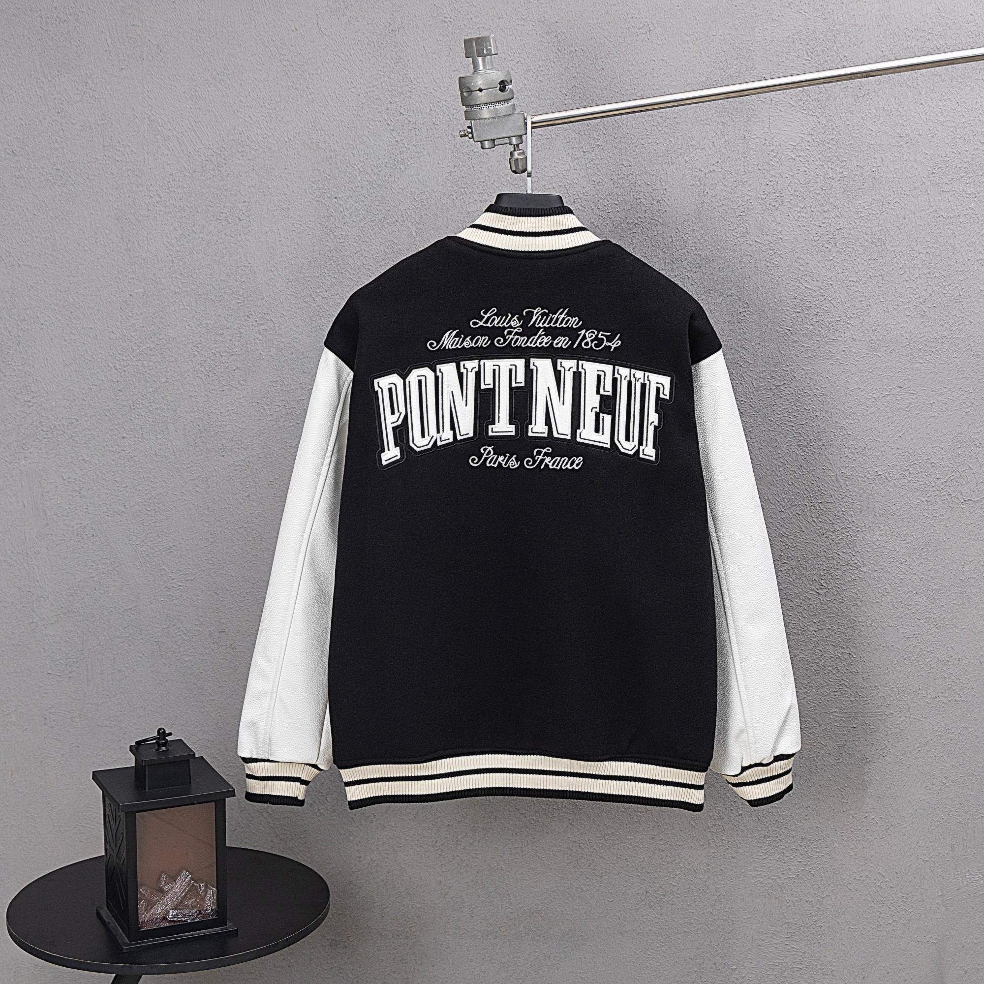 Black varsity jacket with 'PONT NEUF' back graphic and striped cuffs