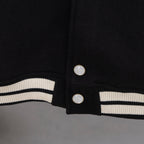 Black jacket hem with ribbed white-and-black stripe band and two snap buttons