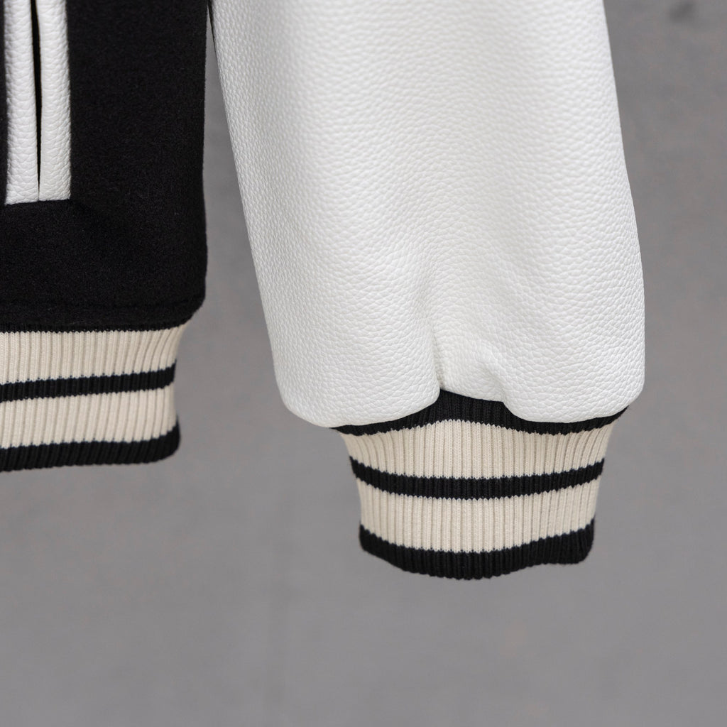 White faux-leather sleeve with ribbed black-and-white striped cuff