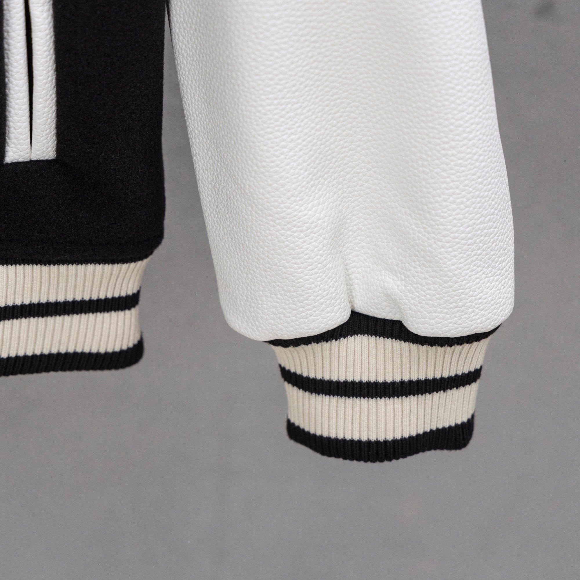 White faux-leather sleeve with ribbed black-and-white striped cuff