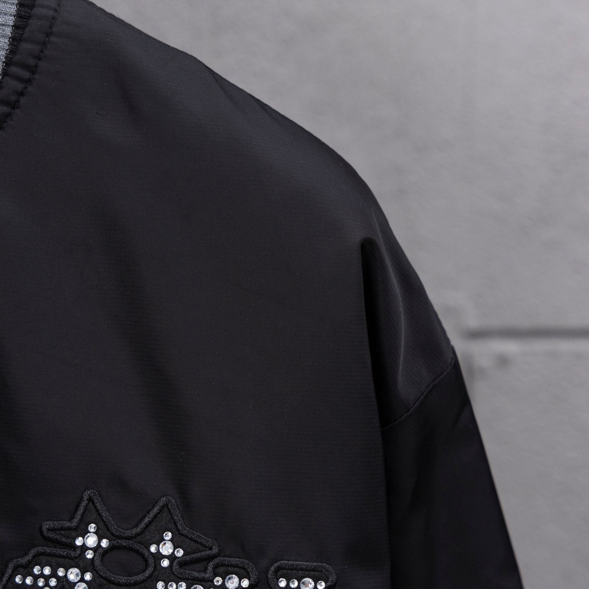 Louis Vuitton jacket sleeve with partial rhinestone crown applique