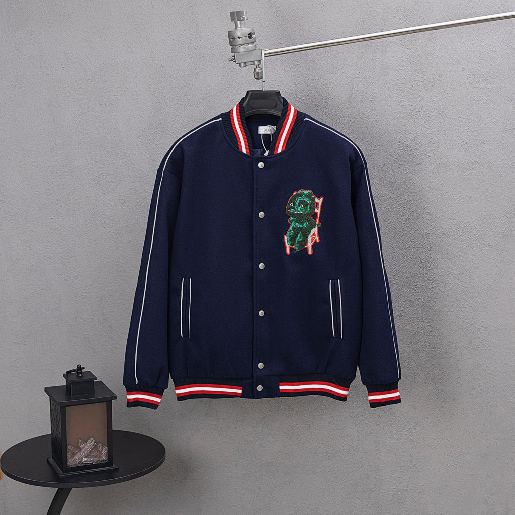 Dark navy varsity jacket with snap front, red/white striped cuffs, dinosaur patch