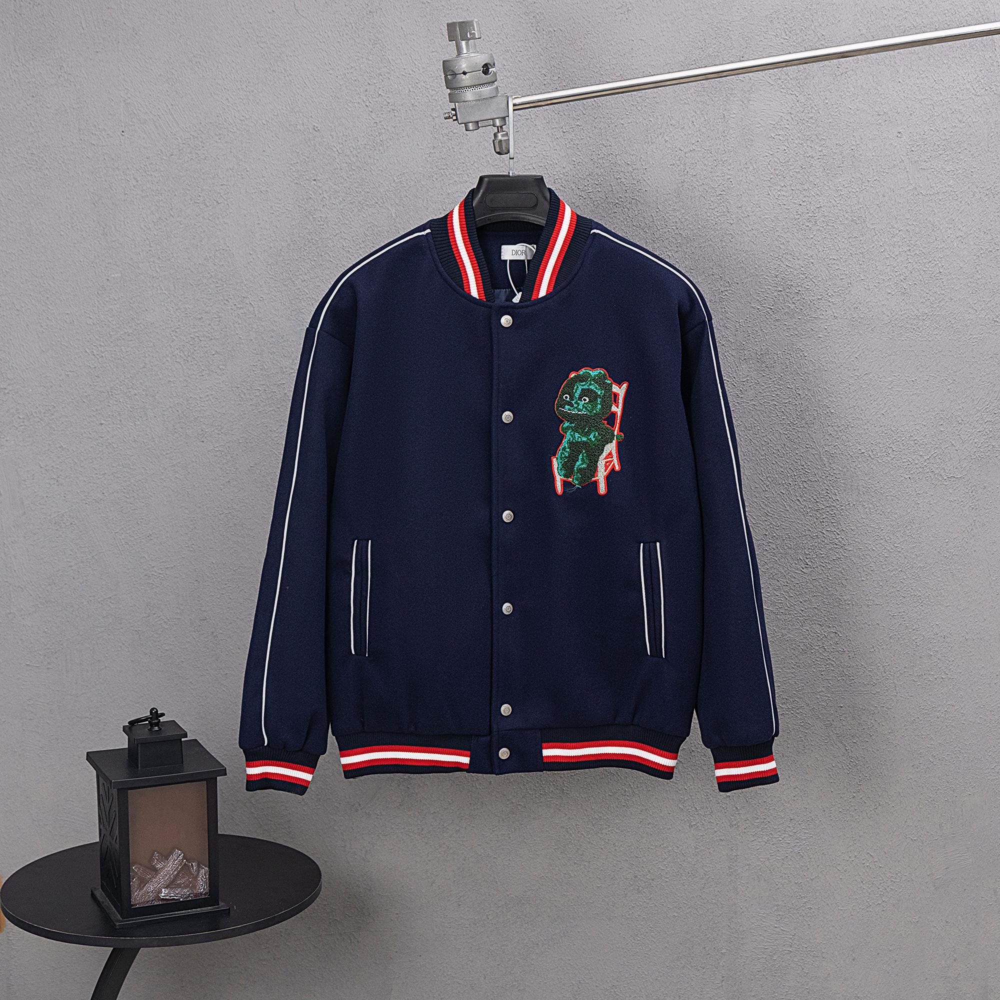 Dark navy varsity jacket with snap front, red/white striped cuffs, dinosaur patch
