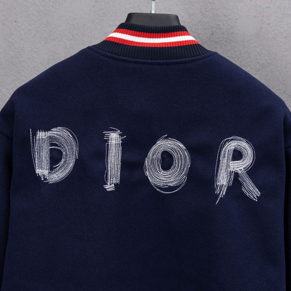Navy jacket back close-up with DIOR embroidered letters and red/white striped collar