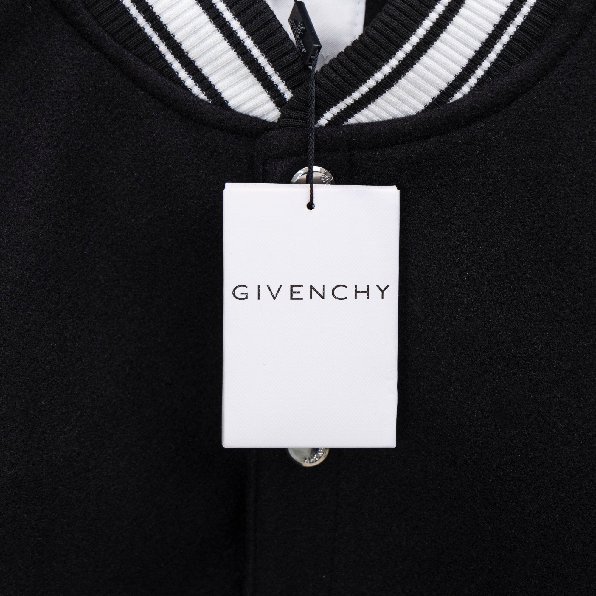 Givenchy clothing label on black knit button placket with white striped collar