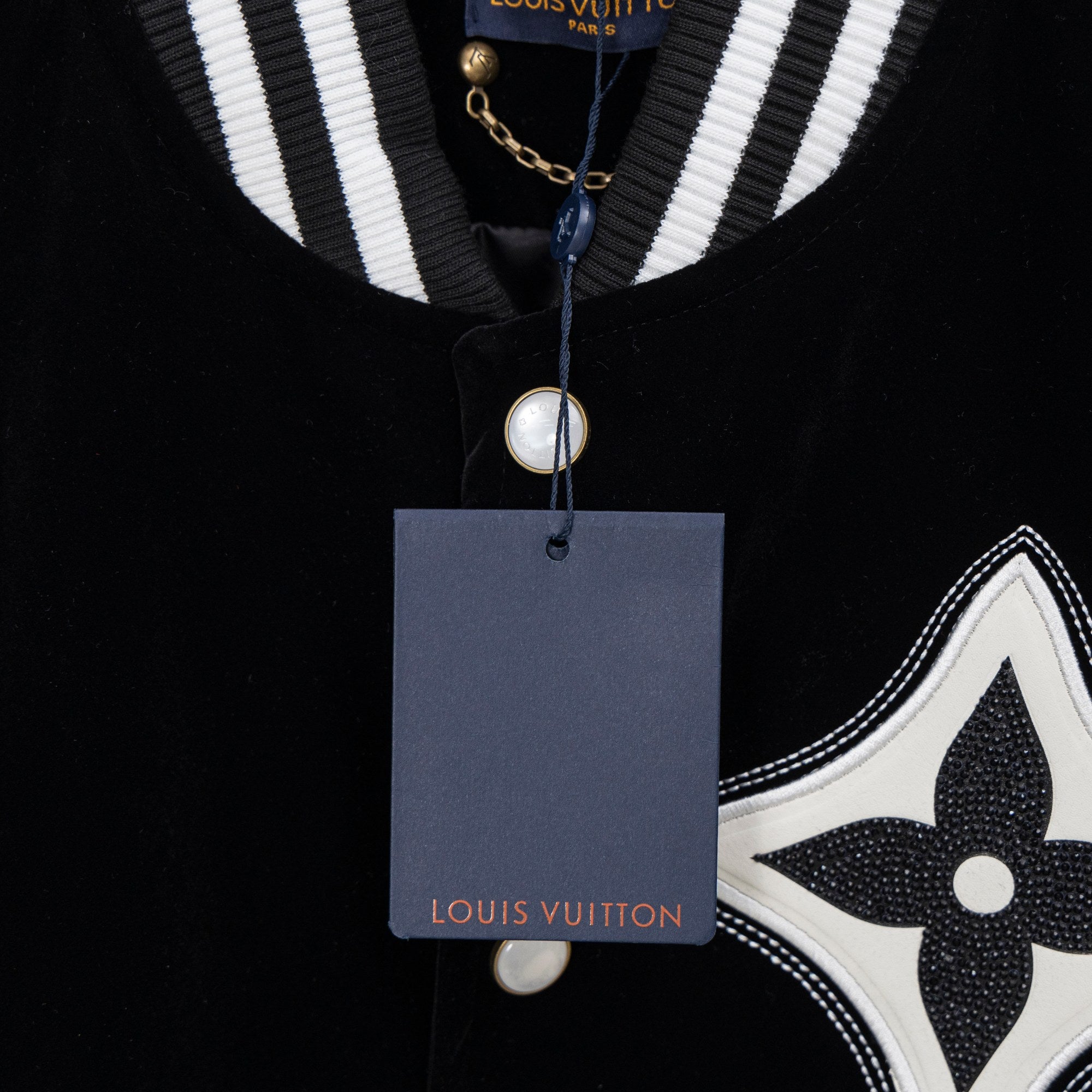 Black long-sleeve polo with striped collar, pearl button, and Louis Vuitton tag
