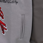 Off White varsity jacket side pocket detail with red logo applique on light gray