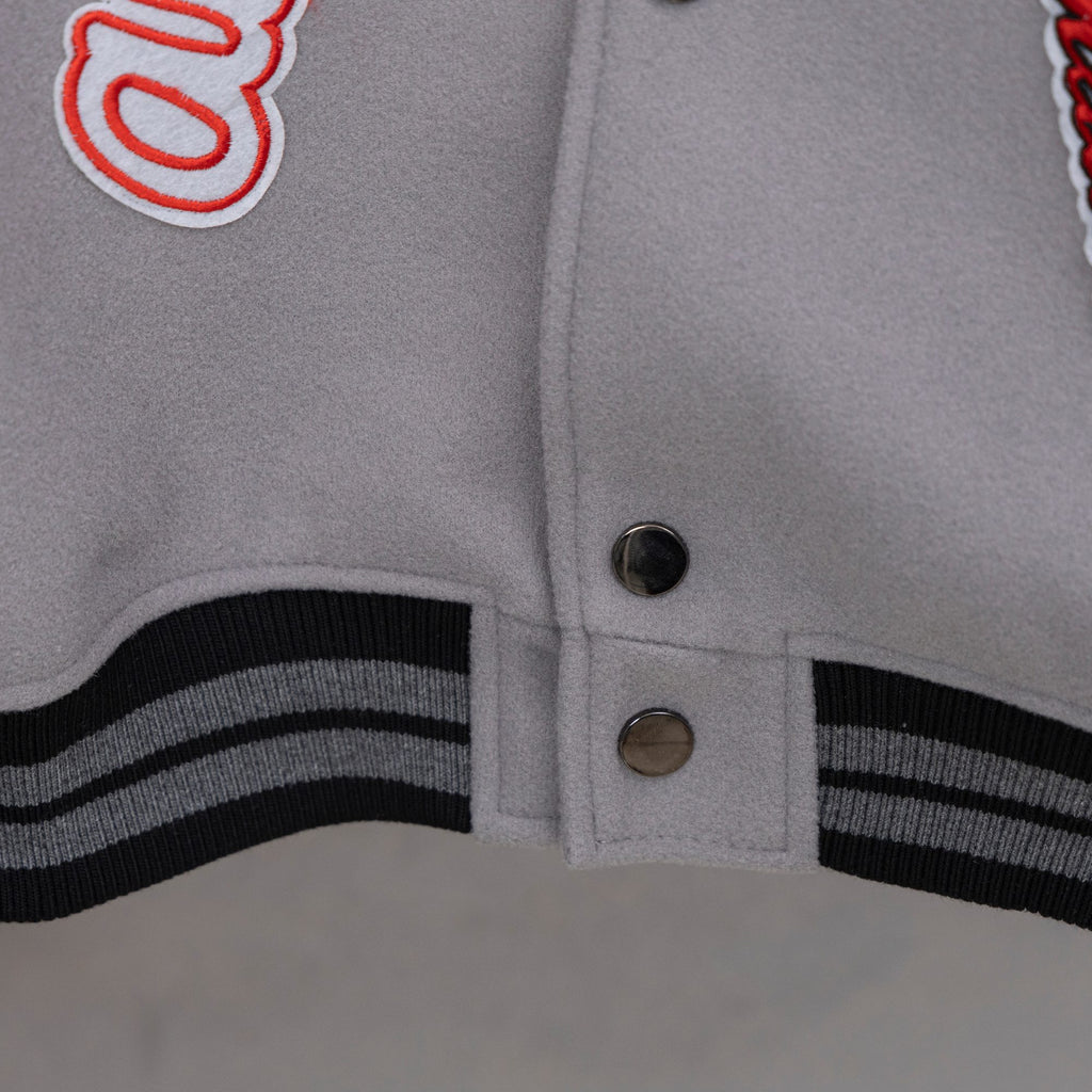 Off White varsity jacket hem cuff with black-and-white striped ribbing and two snap buttons