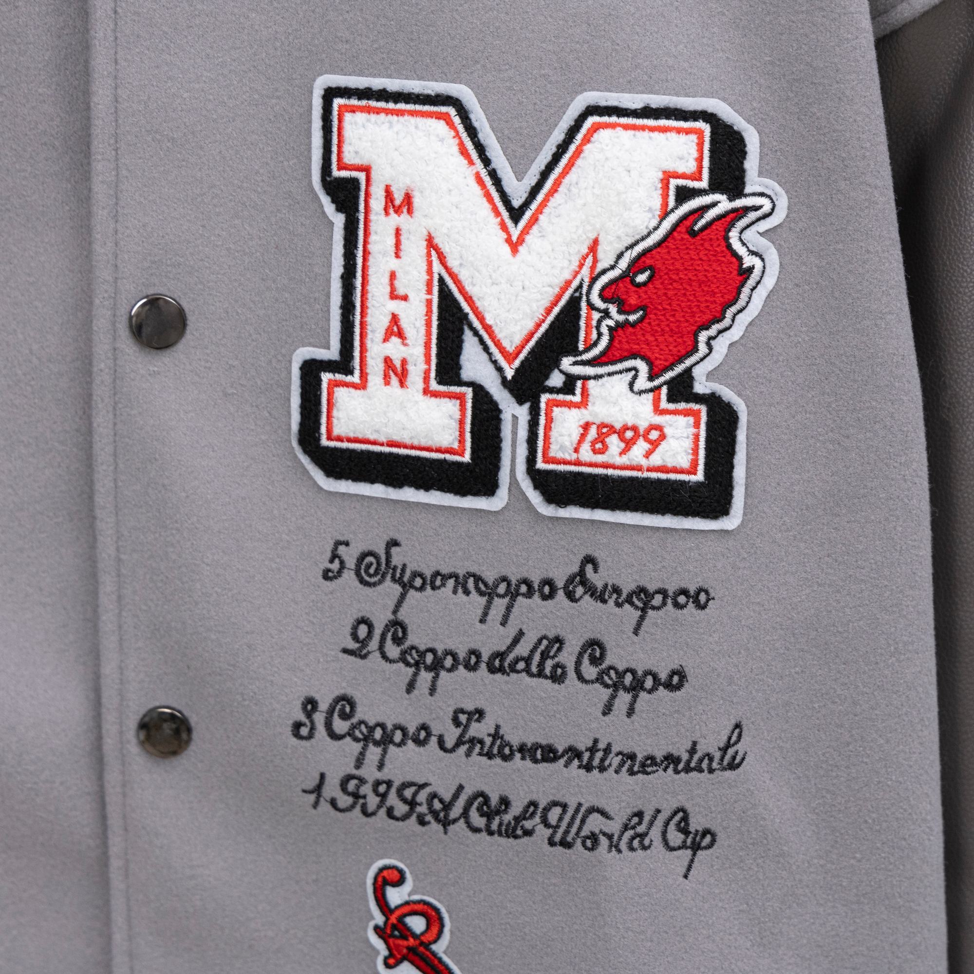 Off White varsity jacket front close-up of large M logo with red animal head and text
