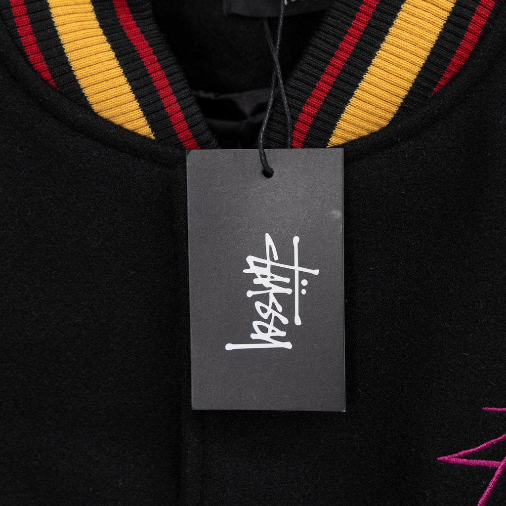 Black jacket neckline with striped trim and hanging product tag