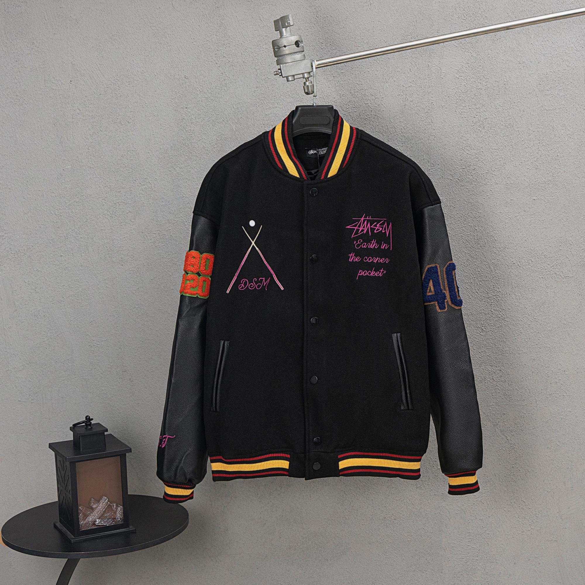 Black varsity jacket with ribbed striped collar, button front, and colorful front graphics