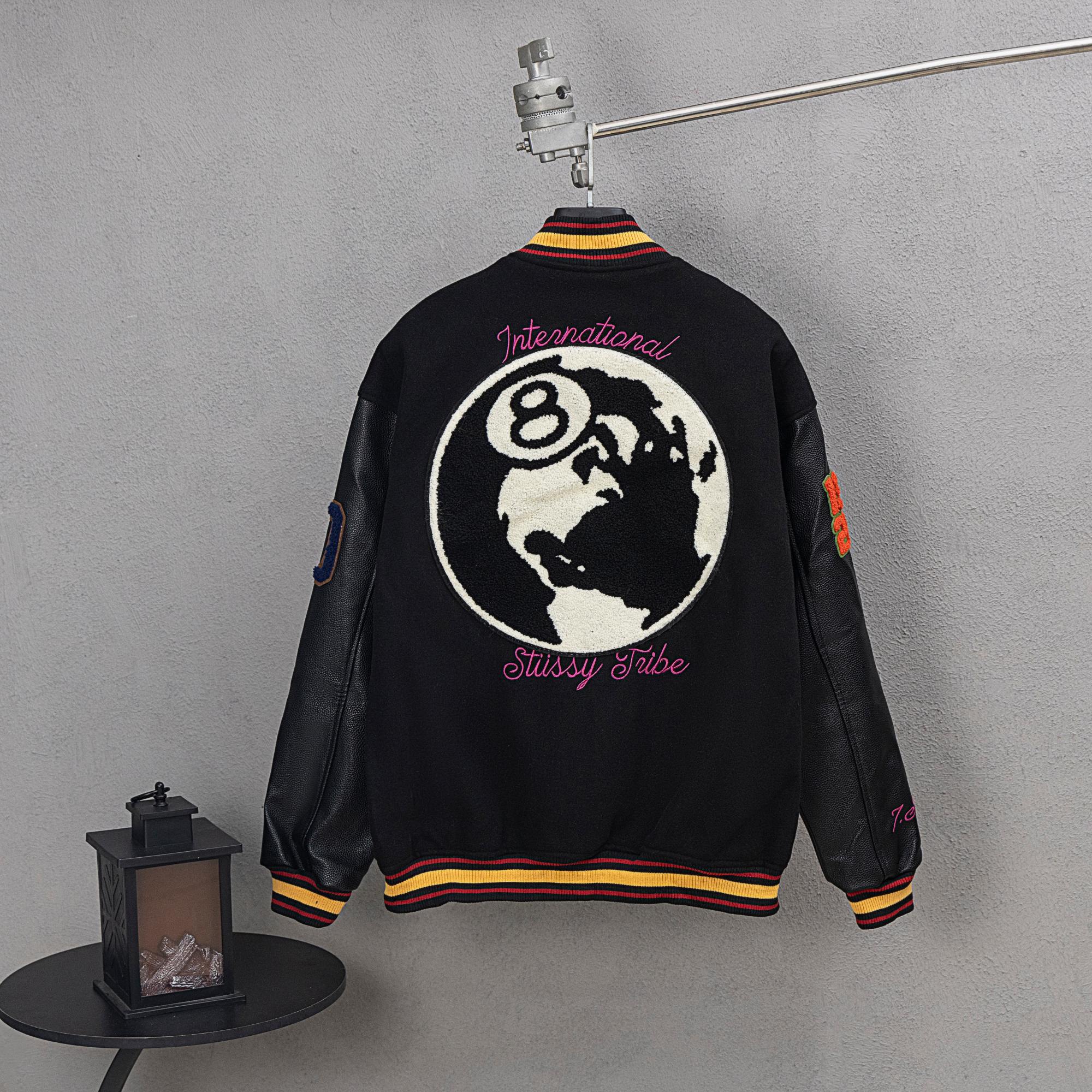Black varsity jacket with globe back graphic and ribbed striped collar and cuffs
