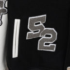 Givenchy jacket front detail with gray stitched numbers and long white sleeve stripe