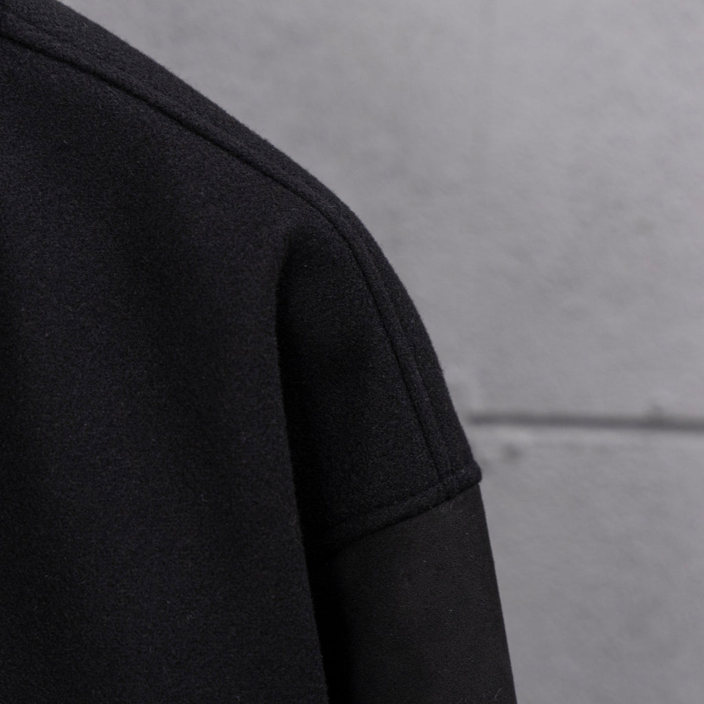 Long jacket sleeve in dark knit with clean seam at shoulder