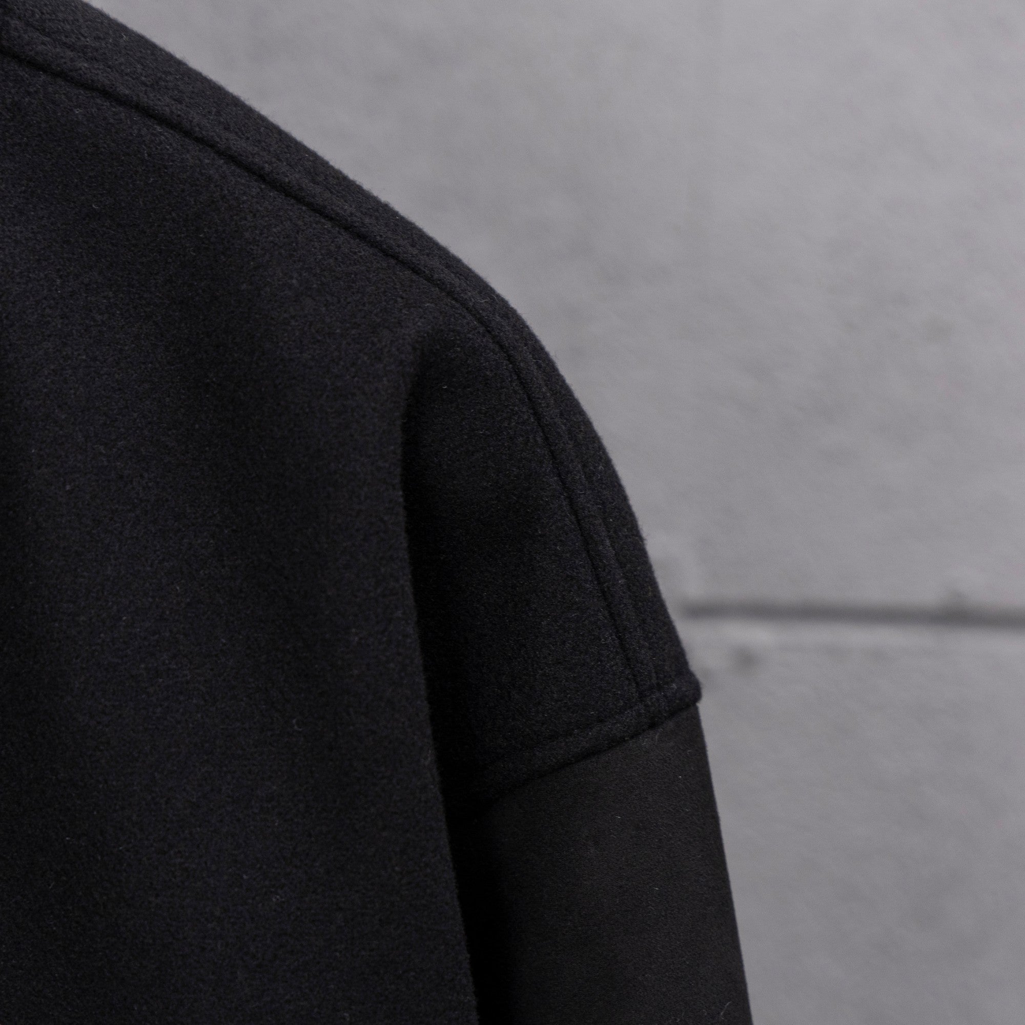 Long jacket sleeve in dark knit with clean seam at shoulder