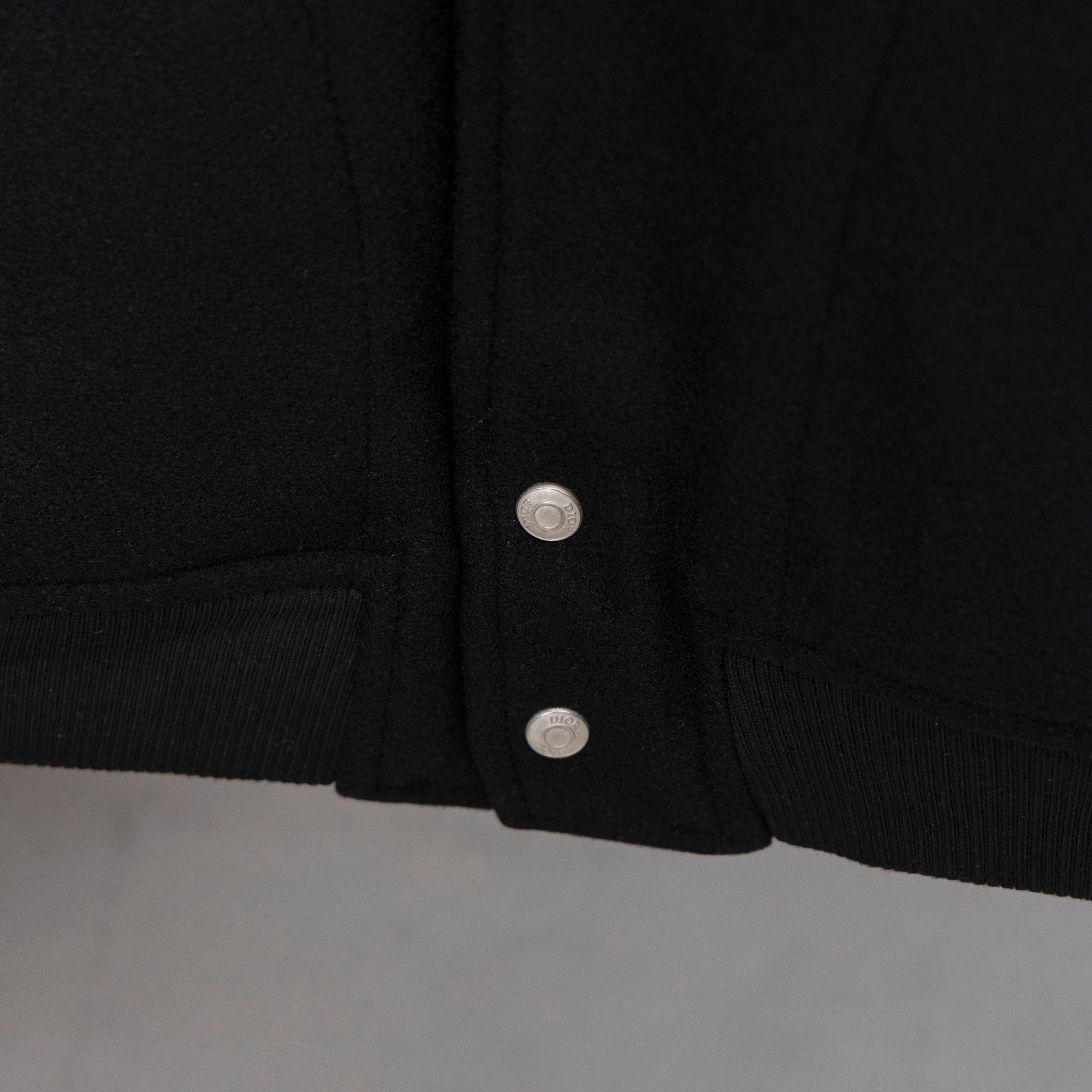 Long jacket hem with ribbed cuffs and two metal snap buttons