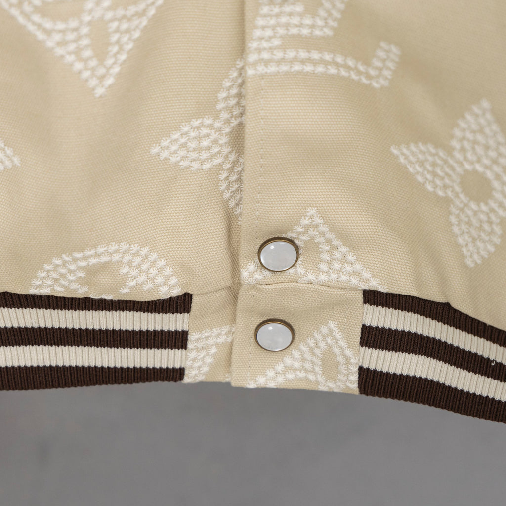 Louis Vuitton jacket front, cream monogram with two button snaps and ribbed striped hem