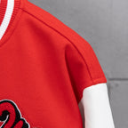 Red jacket fabric close-up with white sleeve cuff and ribbed trim detail