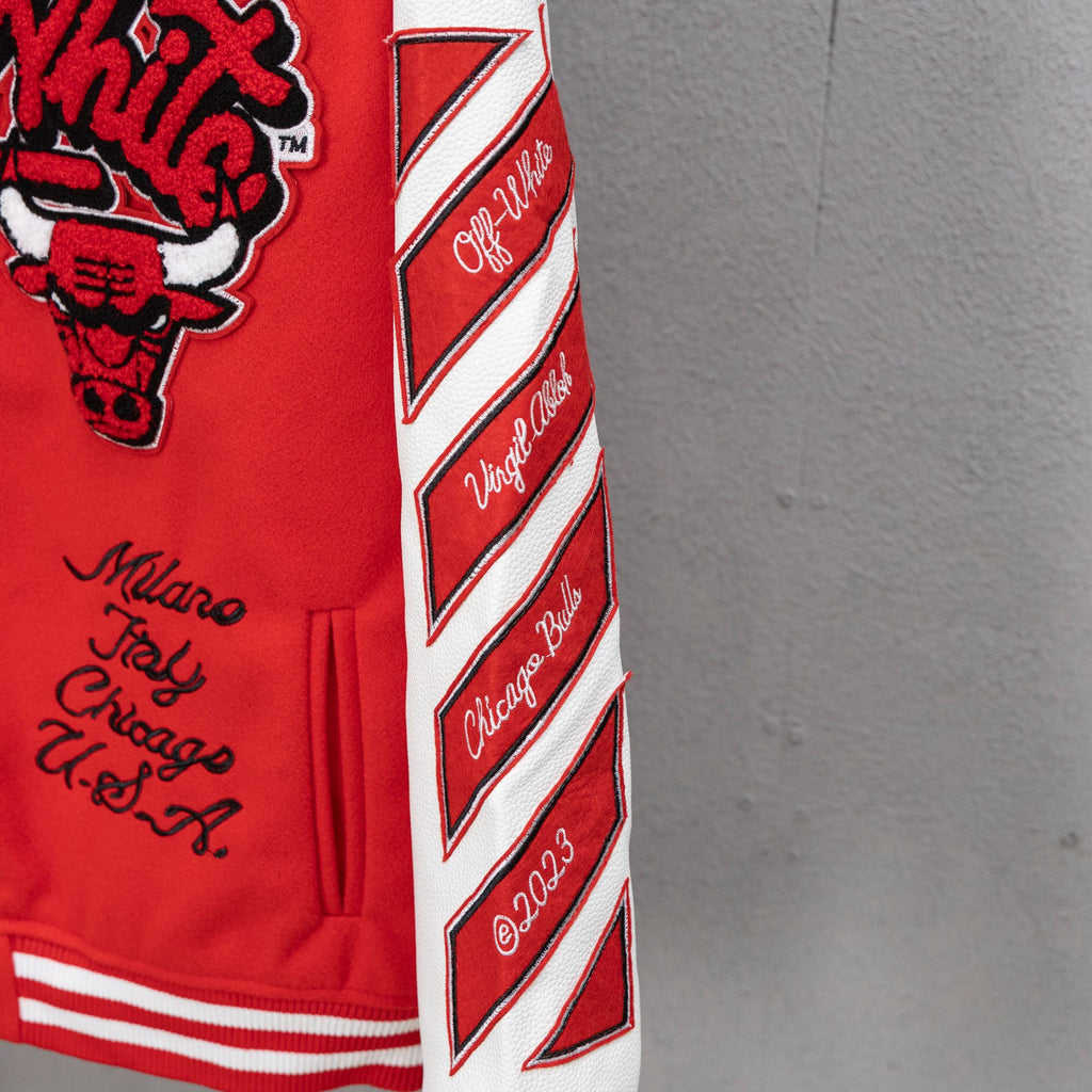 Red jacket side sleeve with white chevron stripes and diagonal logo text