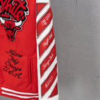Red jacket side sleeve with white chevron stripes and diagonal logo text