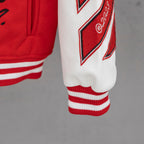 Red sweatshirt cuff with red-and-white striped ribbing and logo patch