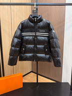 Black puffer jacket with standing collar, Gucci logo patch, zip front and striped chest band.