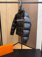 Black long puffer jacket with Gucci logo, stripe detail, zip front and side pockets.