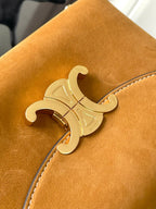 Celine tan leather bag with engraved gold logo emblem on the front panel