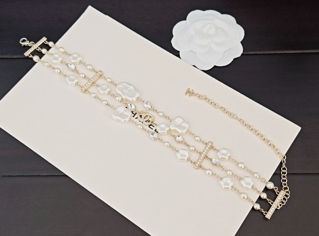 Chanel accessories: pearl and crystal chain bracelets with gold cross and bar charms